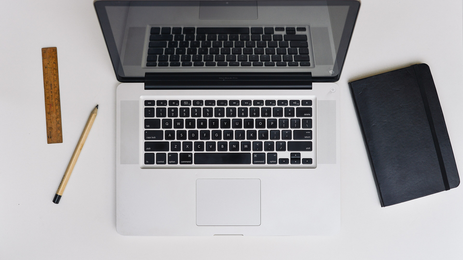 MacBook Pro ouvert sur un bureau en bois